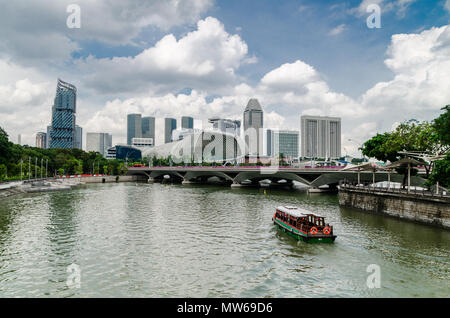 Una barca di crociera noto come twakows corsa attraverso il famoso fiume Singapore. L'edificio sul retro è il famigerato teatro sulla baia, Esplanade. Foto Stock