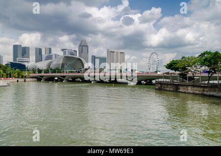 Una barca di crociera noto come twakows corsa attraverso il famoso fiume Singapore. L'edificio sul retro è il famigerato teatro sulla baia, Esplanade. Foto Stock