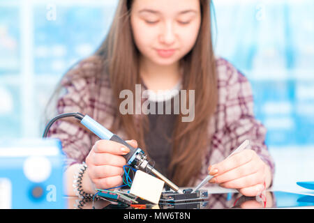 Schoolgirl in robot di laboratorio microcontrollore di debug Foto Stock