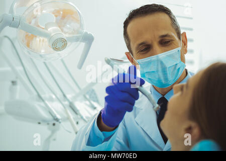 Attento dentista curare il suo paziente Foto Stock