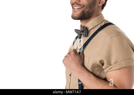 Ritagliato shot di sorridere giovane uomo in calze autoreggenti e bow tie in posa isolato su bianco Foto Stock