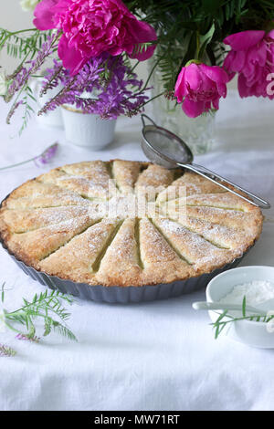 Una grande torta fatta in casa con strisce di rabarbaro in forma di stagno. In stile rustico, il fuoco selettivo. Foto Stock