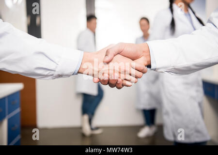 Ritagliato colpo di lavoratori medici stringono le mani Foto Stock