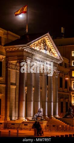 Architettura Spagnola di luci con bandiera sul tetto con la luna piena sul background e persone non focalizzato Foto Stock