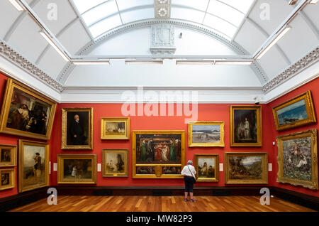 Donna che guarda dipinti nella galleria di Victoria all'interno della McManus galleria d'arte e museo di Dundee, Tayside, Scotland, Regno Unito Foto Stock