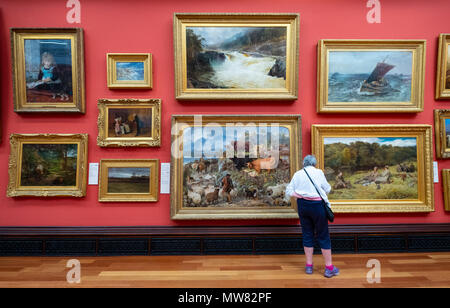 Donna che guarda dipinti nella galleria di Victoria all'interno della McManus galleria d'arte e museo di Dundee, Tayside, Scotland, Regno Unito Foto Stock