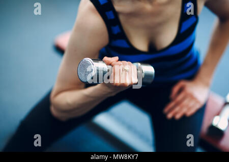 Giovane donna esercizio bicipiti. Fitness in palestra. Foto Stock