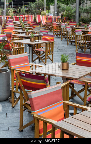 Un gran numero di tela indietro sedie, sdraio ricamato in materiali stripey in arancione e vivacemente colorato essendo utilizzati come posti a sedere presso il ristorante Foto Stock