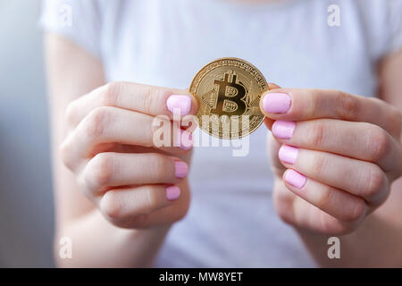 Cryptocurrency golden bitcoin moneta nella donna la mano. Elettronici di denaro virtuale per il web banking e la rete internazionale di pagamento. Simbolo di valuta crypto Foto Stock