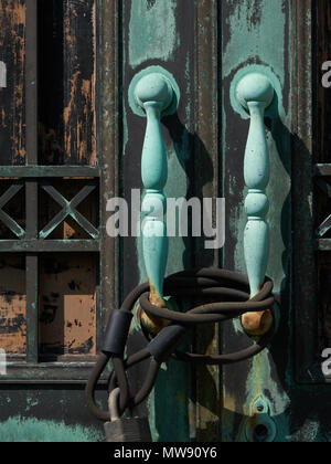 Vecchio doorhandles su porte chiuse di edificio abbandonato Foto Stock
