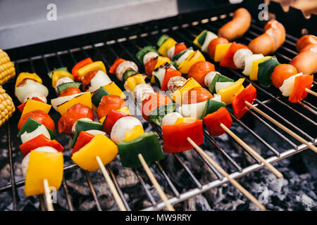 Verdure estive con funghi su spiedini e salsicce alla griglia per il barbecue all'aperto Foto Stock