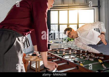 Felice colleghi tavolo da gioco a calcio a un ufficio moderno Foto Stock