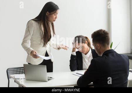 Arrabbiato asian executive grida di subordinati scolding per bad Foto Stock