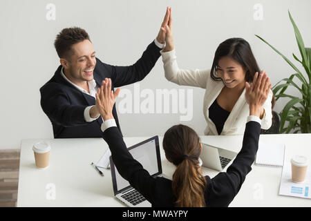 Emozionato multirazziale team holding hands dando alta cinque celebrat Foto Stock