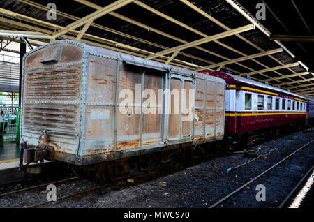 Vecchio weathered rampa tailandese carro merci e passeggeri Trasporto ferroviario parcheggiato a stazione ferroviaria piattaforma Hua Lamphong Bangkok in Thailandia Foto Stock
