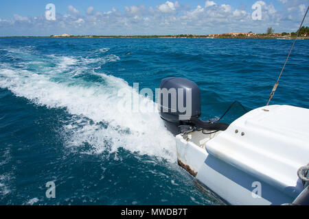 Il sentiero sulla superficie dell'acqua dietro di rapido movimento catamarano a motore nel Mar dei Caraibi Cancun Messico. Estate giornata di sole, cielo blu con nuvole Foto Stock