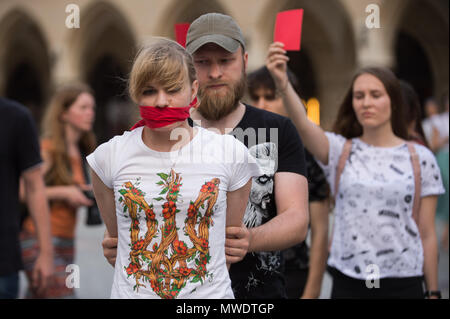 Cracovia in Polonia. Il 1 giugno, 2018. Una ragazza ucraina con un rosso scarve che copre la bocca assiste una protesta chiedendo il rilascio del regista ucraino e scrittore, Oleg Sentsov presso la Piazza Principale di Cracovia.Oleg Sentsov è stato condannato da una corte russa il 25 agosto 2015 a venti anni per la pianificazione di un attentato terroristico alla penisola di Crimea annessa dalla Russia nel mese di aprile 2014. Credito: Omar Marques/SOPA Immagini/ZUMA filo/Alamy Live News Foto Stock