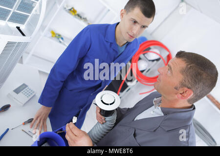 Apprendista elettricista utilizzando tubi di ventilazione Foto Stock