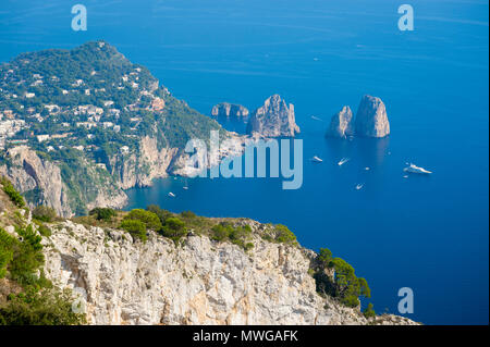 Luminoso vista panoramica dei mitici Faraglioni dal cliffside trail sull'isola Mediterranea di Capri, Italia Foto Stock