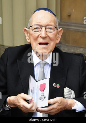 Il tenente colonnello Mordaunt Cohen, 101, tiene il suo MBE (membro dell'ordine dell'Impero Britannico) dopo che è stato assegnato a lui dalla Regina Elisabetta II per i servizi alla Seconda Guerra Mondiale l'istruzione durante una cerimonia di investitura a Buckingham Palace a Londra centrale. Foto Stock