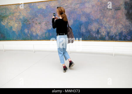 Visitatore fotografare Claude Monet Ninfee Nymphéas pittura presso il Musée de l'Orangerie des Tuileries con telefono cellulare in Parigi Francia KATHY DEWITT Foto Stock