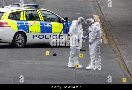 Gli ufficiali forensi mettere un coltello in una busta di prova come essi indagare sulla scena di un incidente in giardini Gateside, Greenock, dove due poliziotti sono stati feriti. Foto Stock