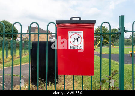 Un vassoio di colore rosso per mettere dog poo in, dopo pulizia dopo il vostro cane fa un pasticcio. Foto Stock