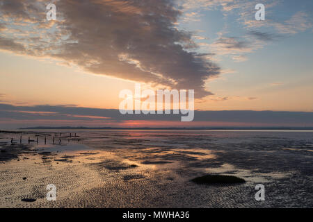 Vivace e interessante forma di nuvole al tramonto visto da Seasalter spiaggia che si affaccia Swale estuario e l'Isle of Sheppey, Kent, Regno Unito. Foto Stock