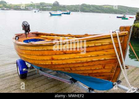 Il clinker costruita imbarcazione in legno sabbiato e verniciato fasciame, sul proprio rimorchio in attesa di essere lanciato in castletownshend, Irlanda. Foto Stock