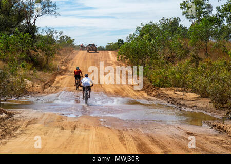 I ciclisti in sella a una fatbike e una mountain bike Escursioni in bicicletta attraverso il fiume che attraversa in Gibb Challenge 2018 sulla Gibb River Road WA Kimberley Australia Foto Stock