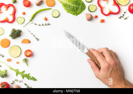 Immagine ritagliata dell'uomo mettendo il coltello sul tavolo isolato su bianco Foto Stock