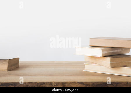 Pila di libri vecchi sul tavolo di legno su bianco Foto Stock