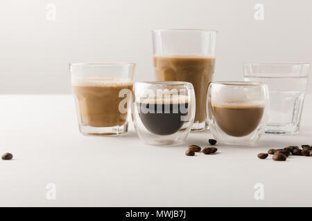 Serie di tazze con assortimento di bevande di caffè su sfondo bianco Foto Stock