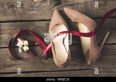 Lay piatto con nastro, corpino, bridal e sposi scarpe sul tavolo in legno Foto Stock