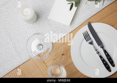 Bicchieri sul tavolo accanto alla scheda in bianco su sfondo tabella Foto Stock