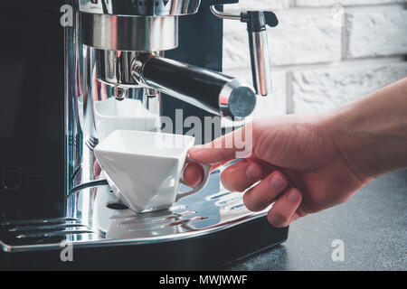 Una tazza bianca sotto la macchina del caffè Foto stock - Alamy