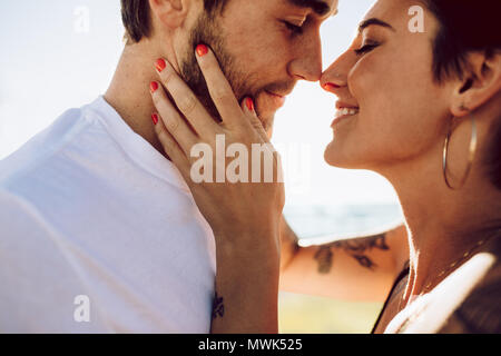 Close up di romantica coppia giovane insieme all'esterno. Amare l uomo e la donna sorpresa in un momento romantico. Foto Stock