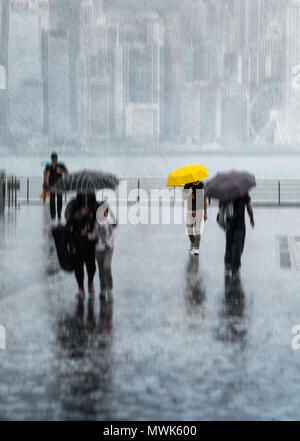 Persone sfocate con ombrelloni camminando per la strada sotto la pioggia forte. Isola di Hong Kong nella foschia sullo sfondo. Ombrello giallo. Foto Stock