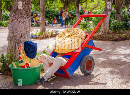 GRANADA, Nicaragua, maggio, 14, 2018: Unidentified uomo prendendo un pisolino all'interno di un carrello di legno e copertura dal sole con un cappello nel parco Xalteva nel centro cittadino Foto Stock