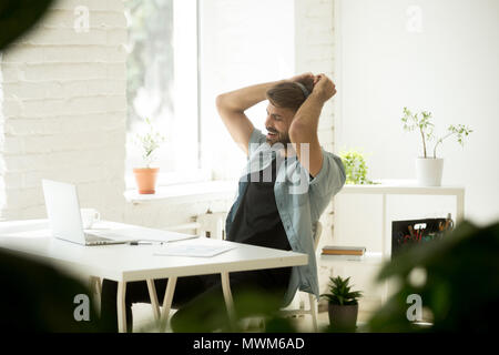 Felice lavoratore nelle cuffie per ascoltare musica e ballo Foto Stock