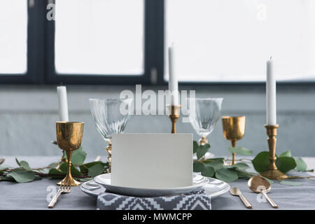 Vista ravvicinata della scheda vuota su piastre sul piano portapaziente con il bellissimo ambiente rustico per gli ospiti Foto Stock