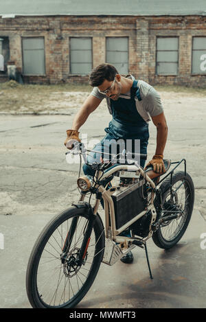 Automechanic nella riparazione di occhiali vintage motociclo fuori al garage Foto Stock