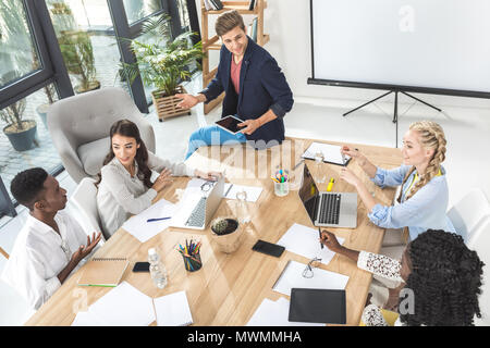 Multiculturale del team aziendale a discutere di nuova strategia e idee alla riunione in ufficio Foto Stock