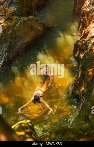 Uomo con azione fotocamera registra la sua ragazza nuotare in un wate Foto Stock