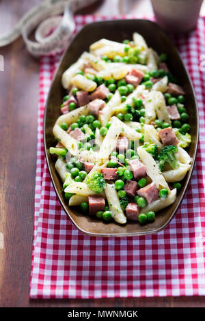 Cuocere la pasta con prosciutto, broccoli e piselli Foto Stock