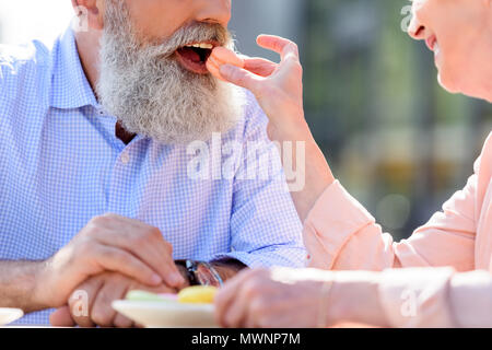 Ritagliato colpo di alimentazione donna uomo senior con amaretto dolce Foto Stock