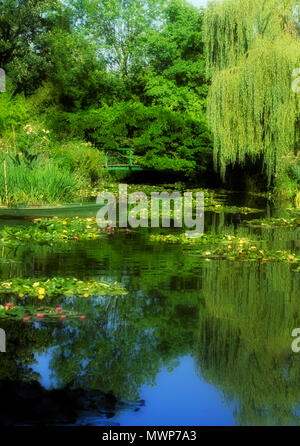 Fotografia di Claude Monet è acqua-lily pond, mostrando un ponte pedonale, con gigli nello stagno (quale dipinse), resi in PS, Giverny, Francia Foto Stock