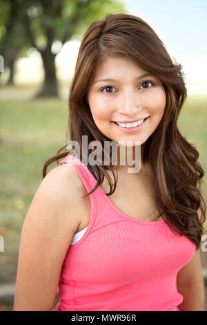 Giovane ragazza ispanica sorridente al di fuori. Foto Stock