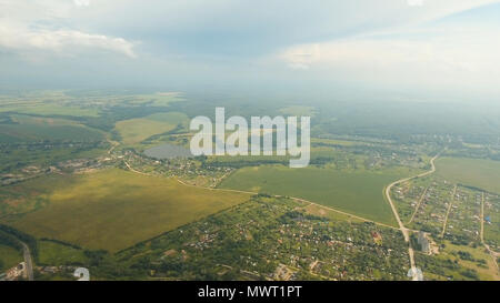 Vista aerea voli al di sopra del lago e il verde dei campi Foto Stock