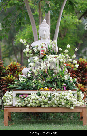 Il buddismo il culto con offrendo fiori e garland alla statua del Buddha su Magha Puja, Asalha Puja e Visakha Puja giorno in Thailandia Foto Stock